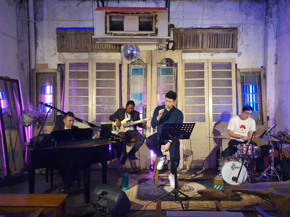 Full live band with grand piano, guitar, drums and vocalist on stage