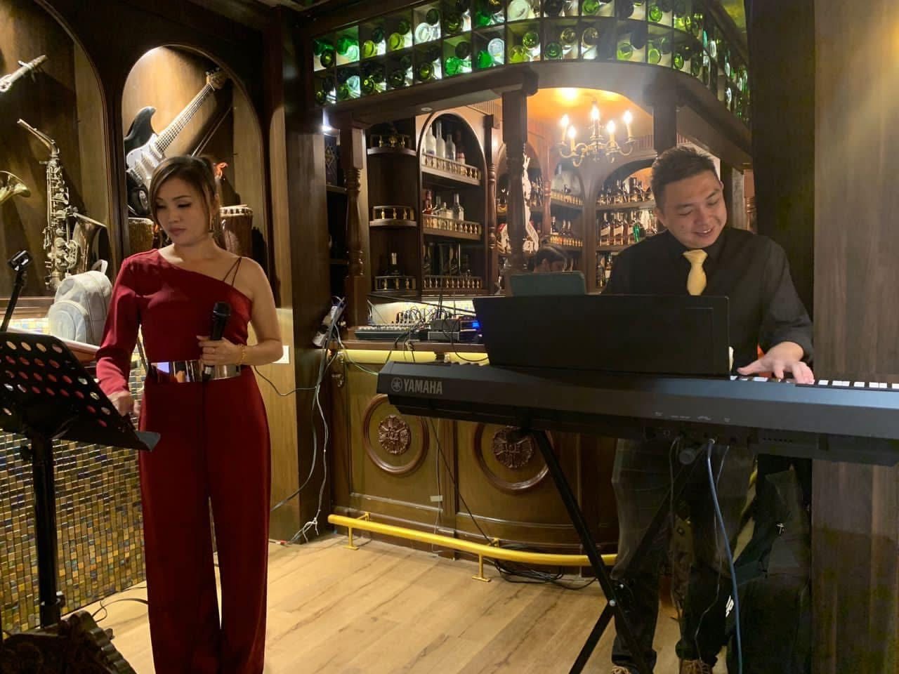 Vocalist and keyboardist performing a jazz set in a warmly lit venue